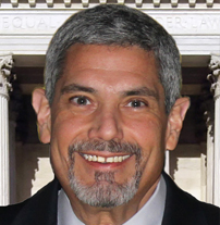 Photo of Rick Carbonara, standing in front of a federal building wearing a suit.